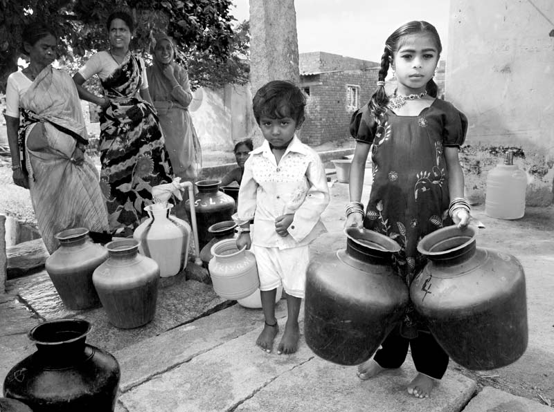 Children and Water - Small children waiting to fill their pots with water at a deep tubewell in a village in Kolar district, Karnataka